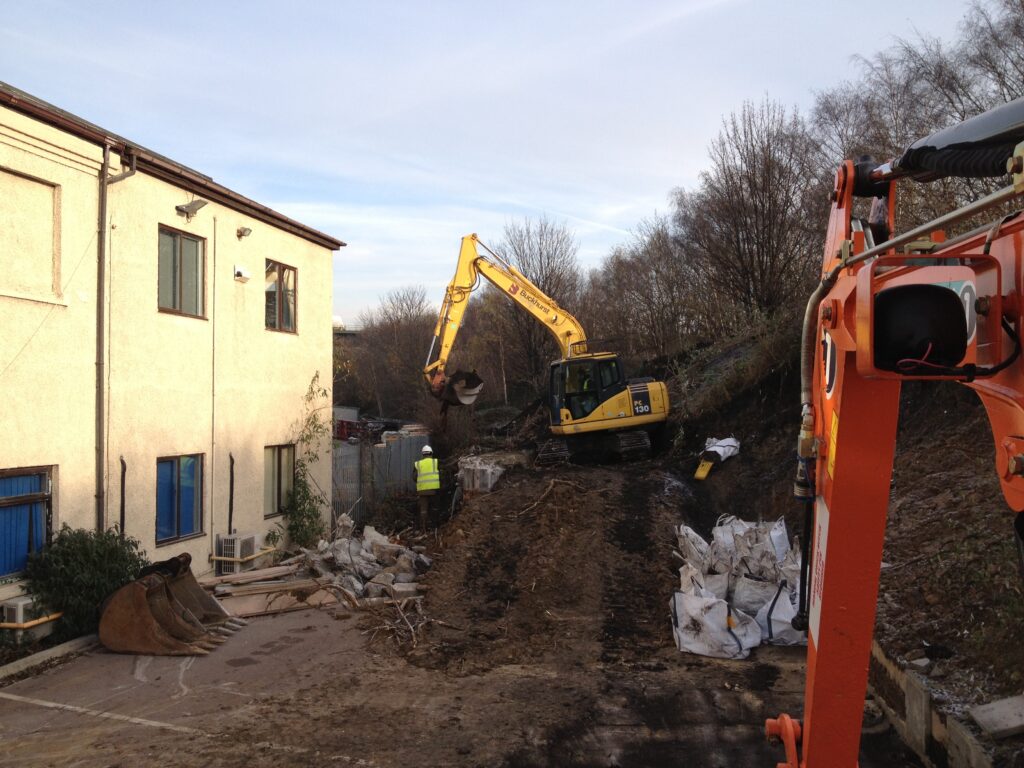 Machines digging out invasive plant roots on a residential site in Swansea