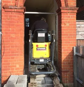 Yellow machine to dig out invasive plant on a residential site in Streatham